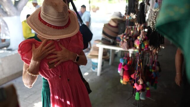 Mature woman picks clothes in a shop while exploring Loreto Baja California Sur in Mexico with a focus on her purchases.