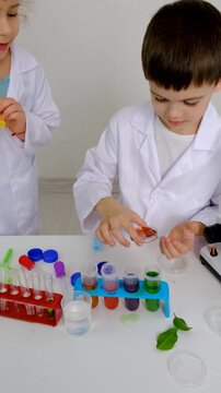 Laboratory examination of a child with test tubes, reagents and a microscope. Selective focus.