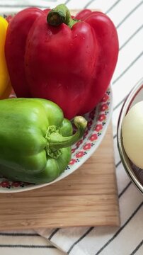 Red tomatoes, onions, and three colors of bell peppers for making spaghetti.