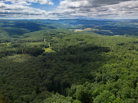Aerial view of the dense green forest and rolling hills of Bohunicky Rohac in Stiavnicke Vrchy under a cloudy sky Bohunice, Nitra Region, Slovakia.