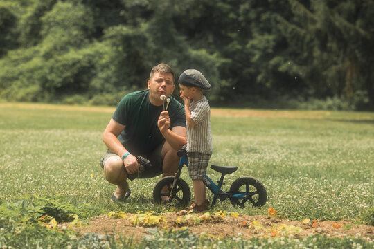 Little kid boy of 3 years and his father in forest with a bicycle. Safety sports leisure with kids concept.