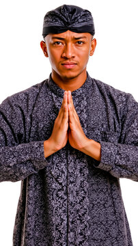 A man in a black and white patterned shirt with his hands clasped together in front of him