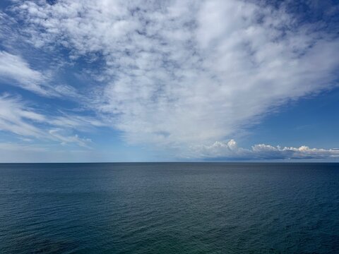 Calm ocean and sky with fluffy clouds.