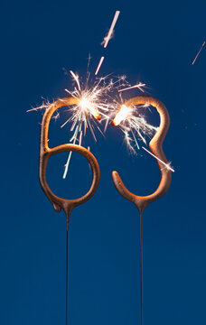 63 years celebration festive background with copy space made with Bengal fires in the form of number Sixty three. Vertical photography.