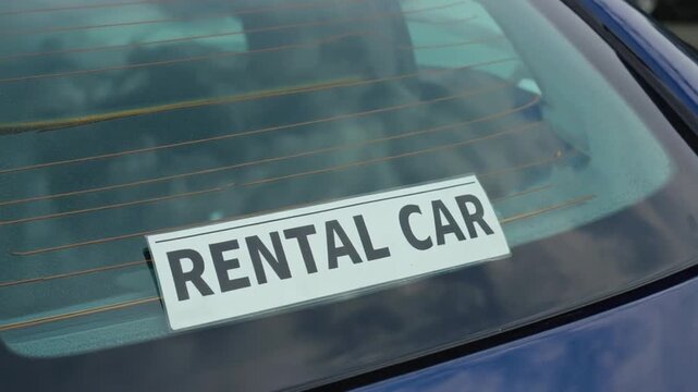 A sticker on a car reads "Rental car".