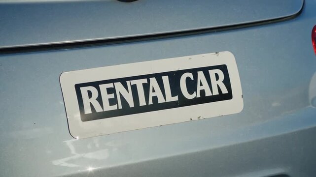 A sticker on a car reads "Rental car".