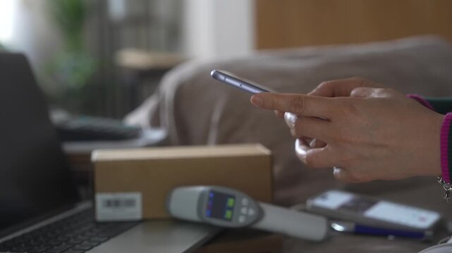 Package tracking and order fulfillment concept with smartphone, shipping box and barcode scanner. Inventory management, shipment verification, ecommerce logistics and warehouse technology workflow