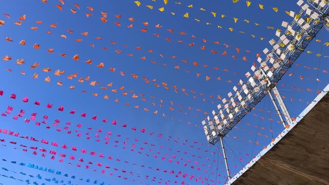 Colorful festival flags under stadium lights