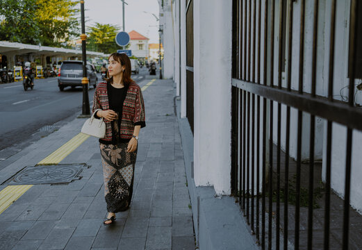 Stylish Asian woman in modern clothes batik walking on the city street, east java, Indonesia.
