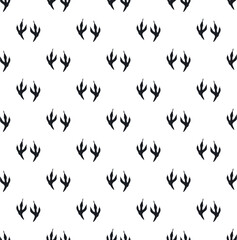 Naklejka premium Repeating black bird claw prints creating a monochrome animal tracking background