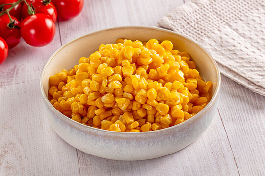 Fresh sweet corn kernels in ceramic bowl with cherry tomatoes