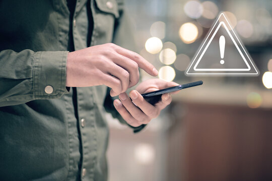 A young man clicks on a virtual screen with a warning sign.