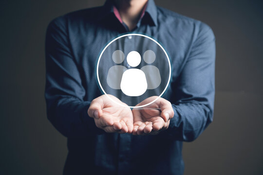 businessman holding a social network icon on a dark background, man and people icon