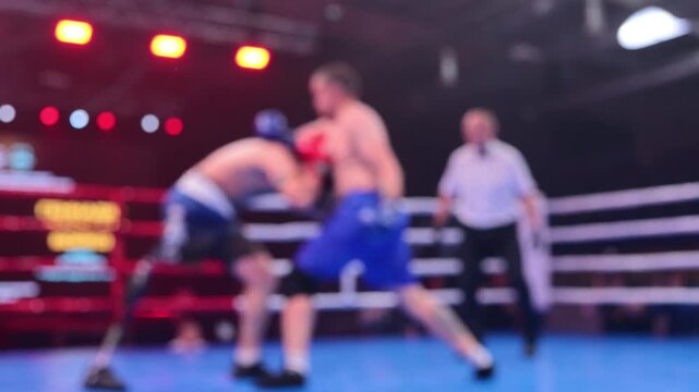 Blurred motion of two boxers exchanging punches in ring during boxing competition