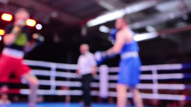 Blurred motion of two boxers exchanging punches in ring during boxing competition