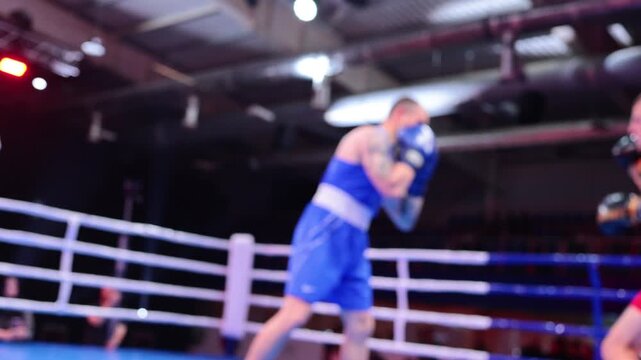 Blurred motion of two boxers exchanging punches in ring during boxing competition
