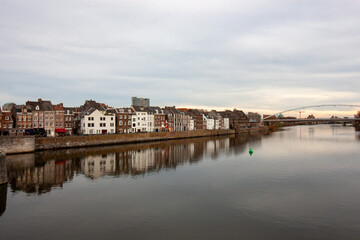Naklejka premium Scenic view of the historic Meuse river embankment with architectural reflections in Maastricht