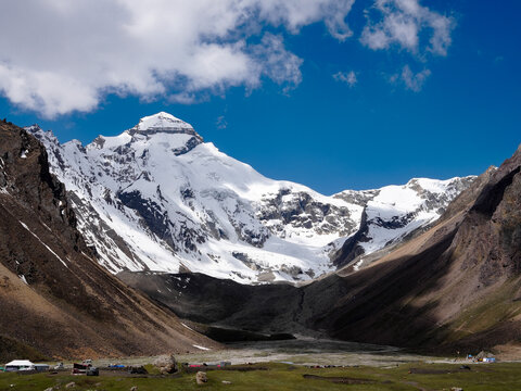 Magestic view of Adi Kailash mountain in Uttarakhand, India, featuring snow-covered Himalayan peaks, rocky valleys, and a clear blue sky.