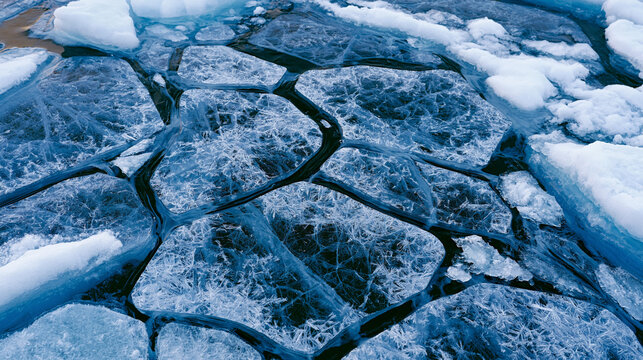 Sea ice brash field aerial, frazil crystal and pancake ice formation mosaic, nilas film connecting floes, brine channel network visible in overcast diffuse polar light, oceanographic ice formation d