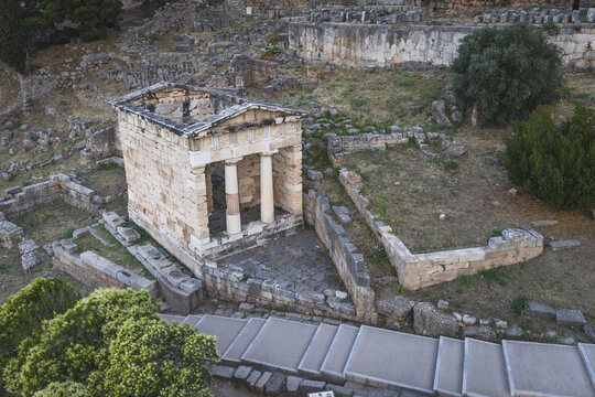 Aerial view of the Treasury of the Athenians with its ancient marble columns and stone ruins on the archaeological site of Delphi, Greece.