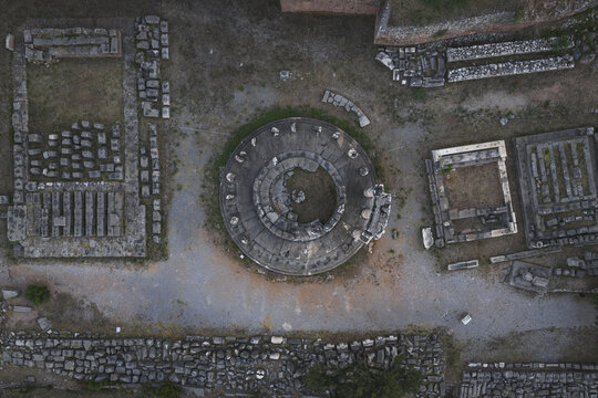 Aerial view of the circular Tholos of Delphi and ancient stone foundations at the archaeological site in Delphi, Greece.