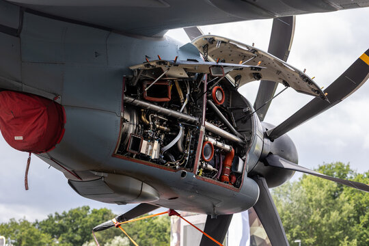 Open turboprop engine nacelle intricate detail network cables pipes mechanical systems large propeller blade. Aerospace engineering maintenance propulsion technology precision manufacturing