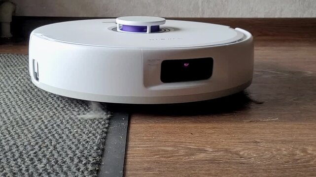The robot vacuum cleaner works and vacuums the room while traveling on the floor. Smart home, home cleaning equipment. High quality 4k footage