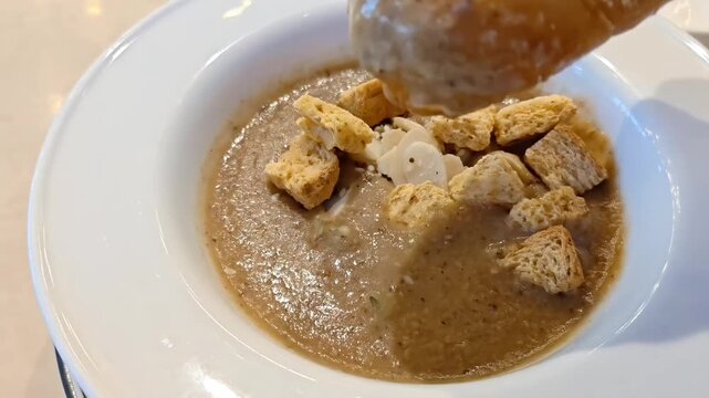 Dipping shio pan bread into Truffle Mushroom Puree Soup, Creamy Healthy Delicacy, Vegetarian Nutrition, Cafe Restaurant Meal