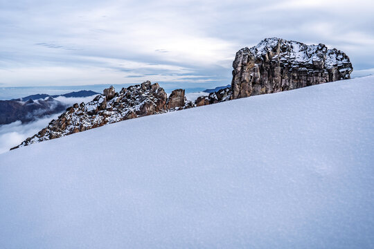 Close-up of a glacier and fresh snow on a snow-capped mountain in Colombia, with a snow-covered rock in the background. Espolon del Gusano, Nevado del Tolima