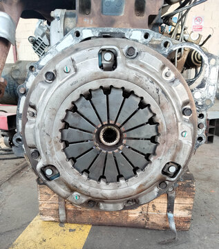 Close-up of a car clutch assembly on a wooden block in a garage