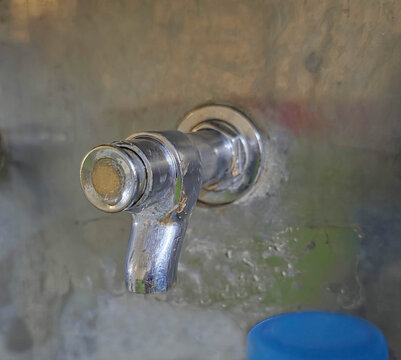 Close-up of a Metal Water Tap with Dripping Water