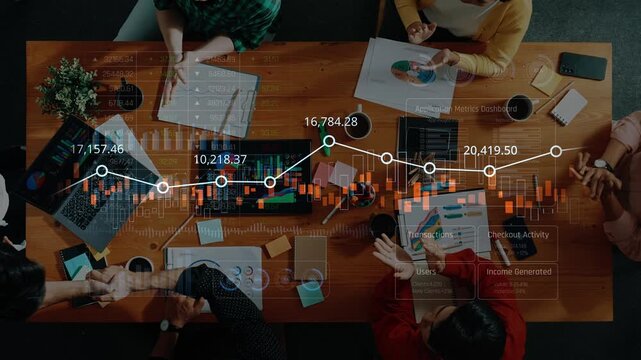A dynamic collaborative business meeting showcasing professionals engaged in data analysis, surrounded by digital charts and financial metrics on a modern workspace table. Raster