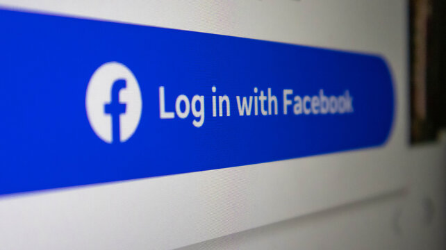 Closeup of a blue button on a computer screen that says log in with facebook