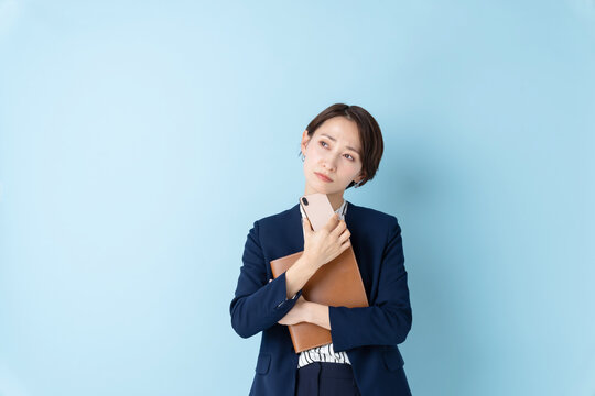 ビジネス　考える女性　ブルーバック