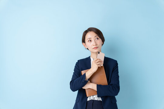 ビジネス　考える女性　ブルーバック