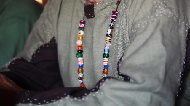 Historical reenactment concept: Detail shot of medieval clothing and an authentic handmade beaded necklace.