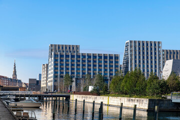 Fototapeta premium Residential area with modern buildings in the dock area of Copenhagen, Denmark with in background the spire of the Church of Our Saviour (Vor Frelsers Kirke)