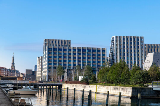 Residential area with modern buildings in the dock area of Copenhagen, Denmark with in background the spire of the Church of Our Saviour (Vor Frelsers Kirke)