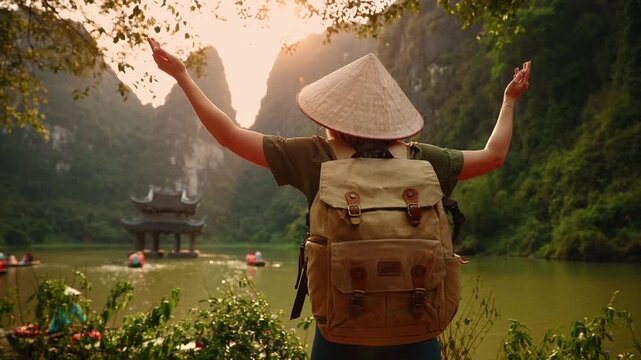 Young female tourist with backpack exploring scenic Ninh Binh mountains and waterways.