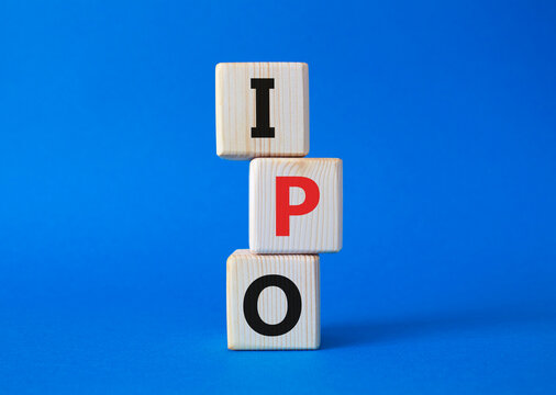 IPO- Initial Public Offering symbol. Concept word IPO on wooden cubes. Beautiful blue background. Business and IPO concept. Copy space.
