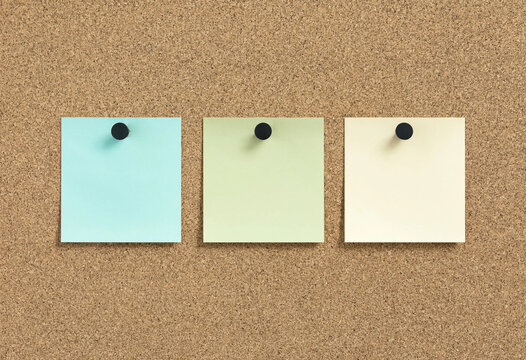 Three blank sticky notes pinned on textured corkboard background flat lay minimalist composition