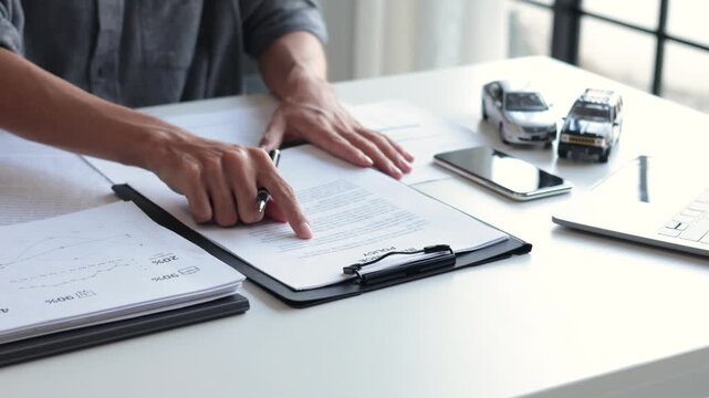 Businessman Reviewing and Signing Car Insurance Policy Contract, Auto Loan Agreement Contract in Office.