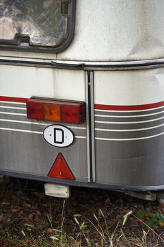 Vintage Wohnwagen und Caravan der Achtziger Jahre und Neunziger Jahre f&uuml;r Camping und Van Life mit Nationalit&auml;tenkennzeichen in Heuchelheim bei Gie&szlig;en in Hessen