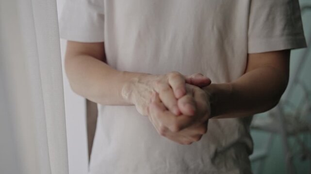 Close-up view of man hands applying moisturizing lotion to dry skin, elbows, arms for allergy relief, psoriasis, eczema treatment in home setting, close-up, slow motion