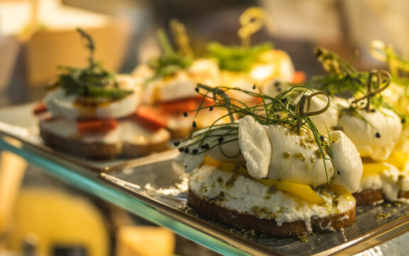 Pinchos gourmet de queso mozzarella y pesto sobre rebanadas de pan