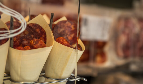 Primer plano de cucuruchos artesanales rellenos de rodajas de chorizo curado listos para llevar. Formato de degustaci&oacute;n r&uacute;stico expuesto en el mostrador de una charcuter&iacute;a.