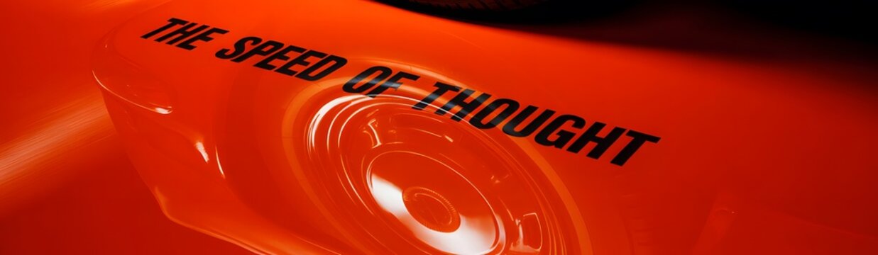 Vibrant orange background with the phrase 'THE SPEED OF THOUGHT' and a sleek, metallic design element.