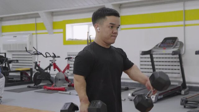 Man with dwarfism training with heavy dumbbell during workout in gym