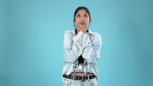 Young asian woman holding hands together in prayer and hoping for luck