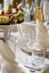Fototapeta premium The image depicts an elegant dining table setting in light tones, creating the atmosphere of a gala event or an upscale restaurant.